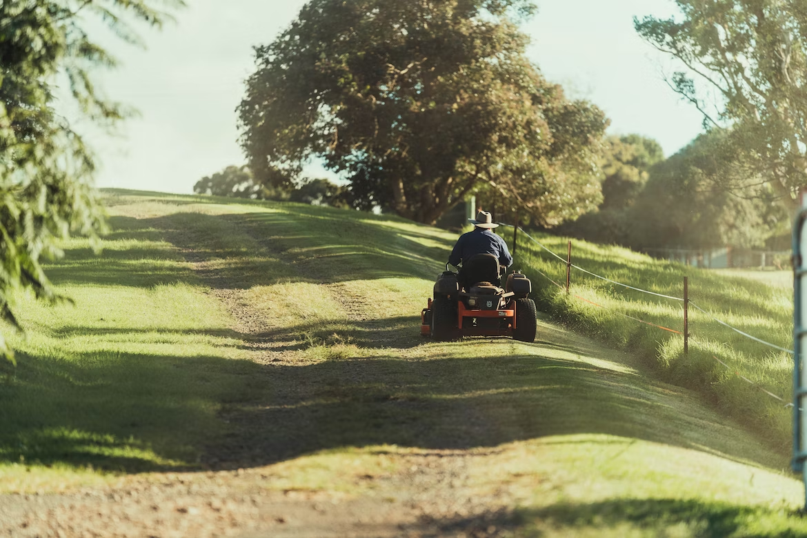 person riding lawn mowerr