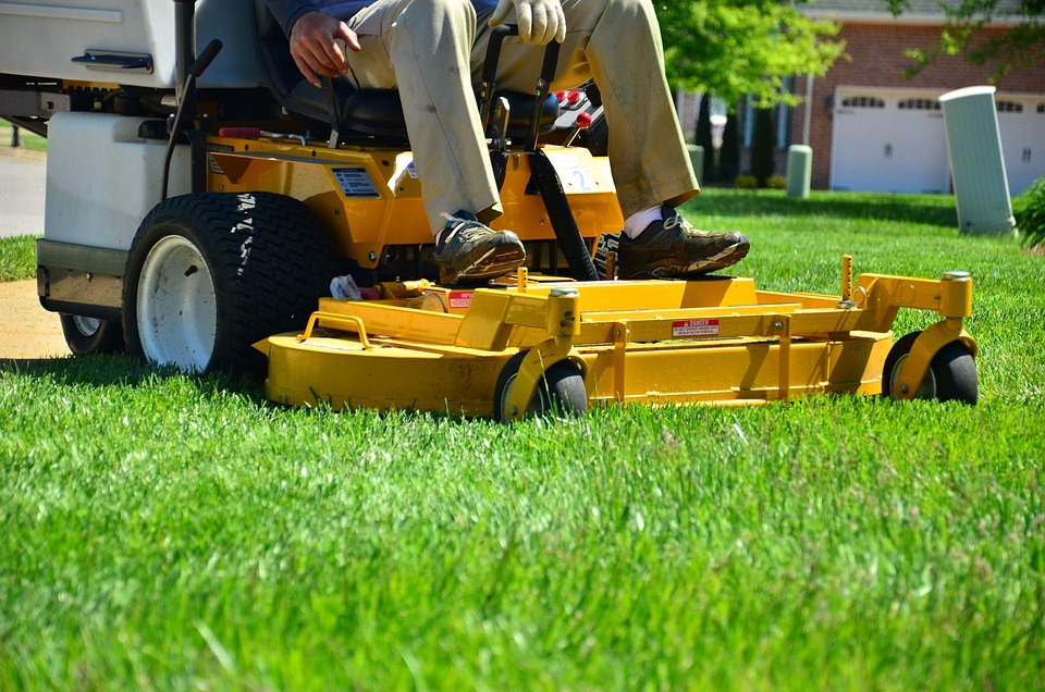 person riding lawn mower