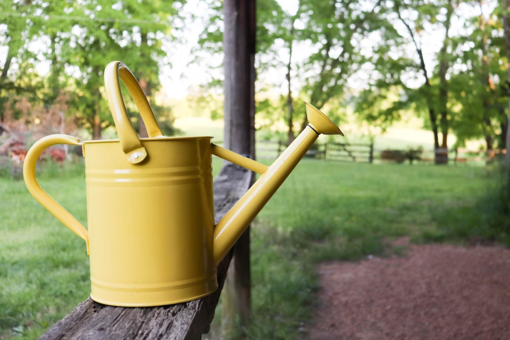 a yellow watering can on a wooden post