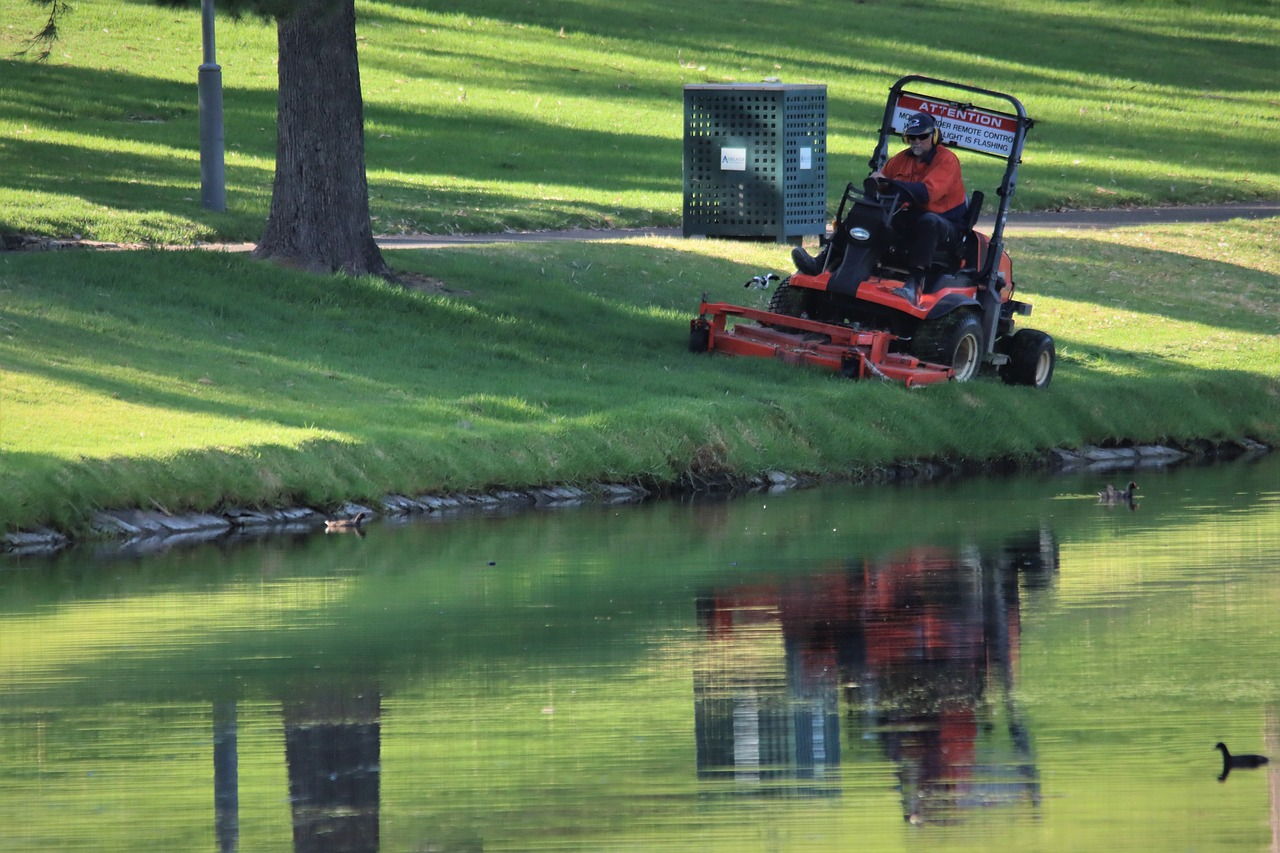 person rriding mower in green field