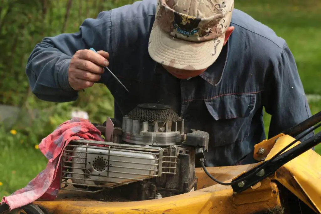 person checking on mower engine